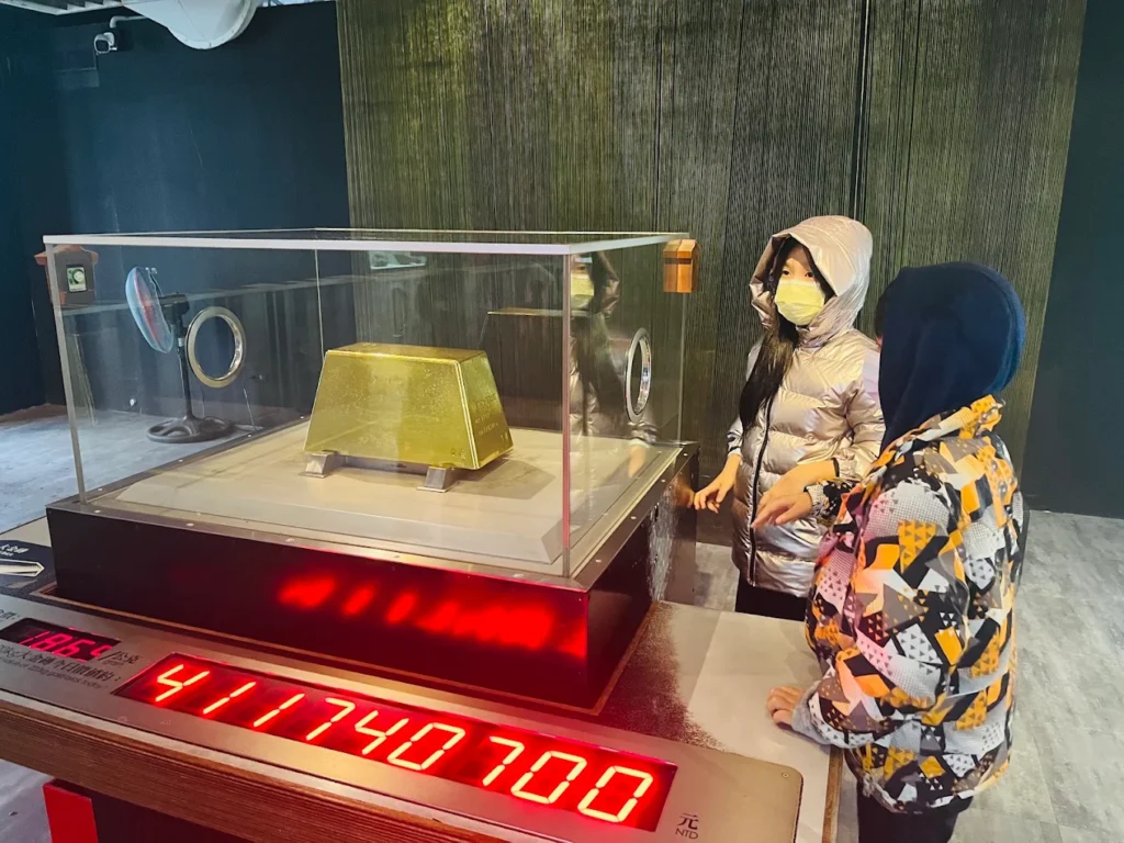 Visitors beside the 220 kg gold bar on display at the Gold Museum in Jinguashi, Taiwan.